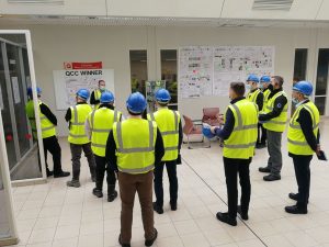 A group of people standing around in hi viz jackets.